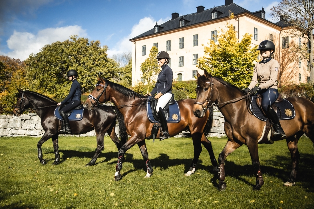 tre tjejer som rider på häst