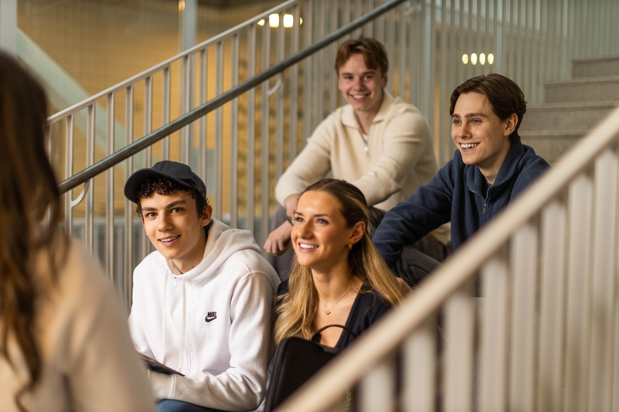 ungdomar sitter på trappa och ler